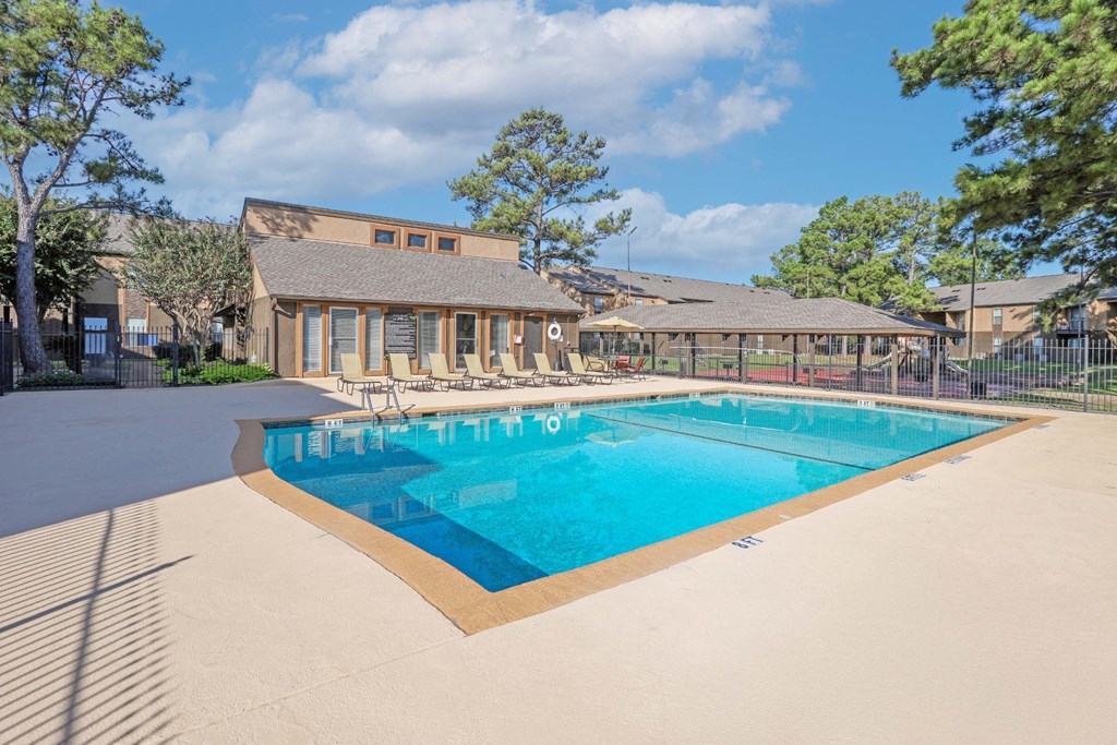 A large swimming pool in front of the leasing office with a sunny day at Stone Canyon apartments in Shreveport, LA.