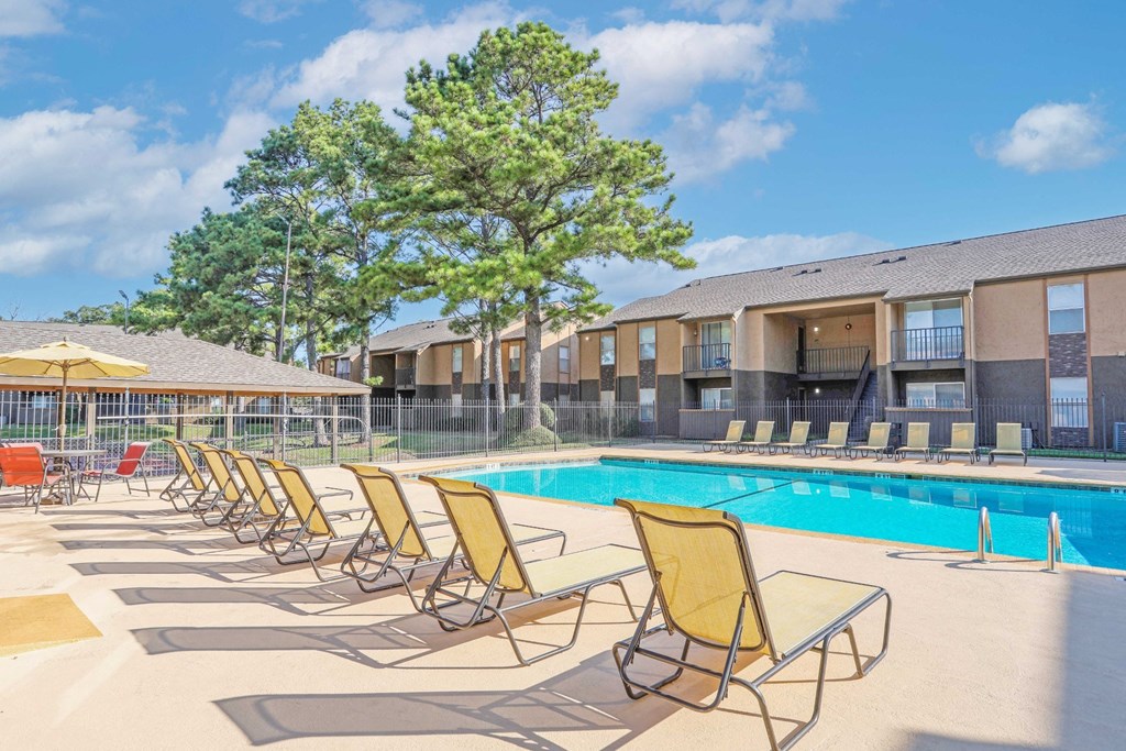 Yellow lounge chairs are lined up by our pool at Stone Canyon apartments in Shreveport, LA.