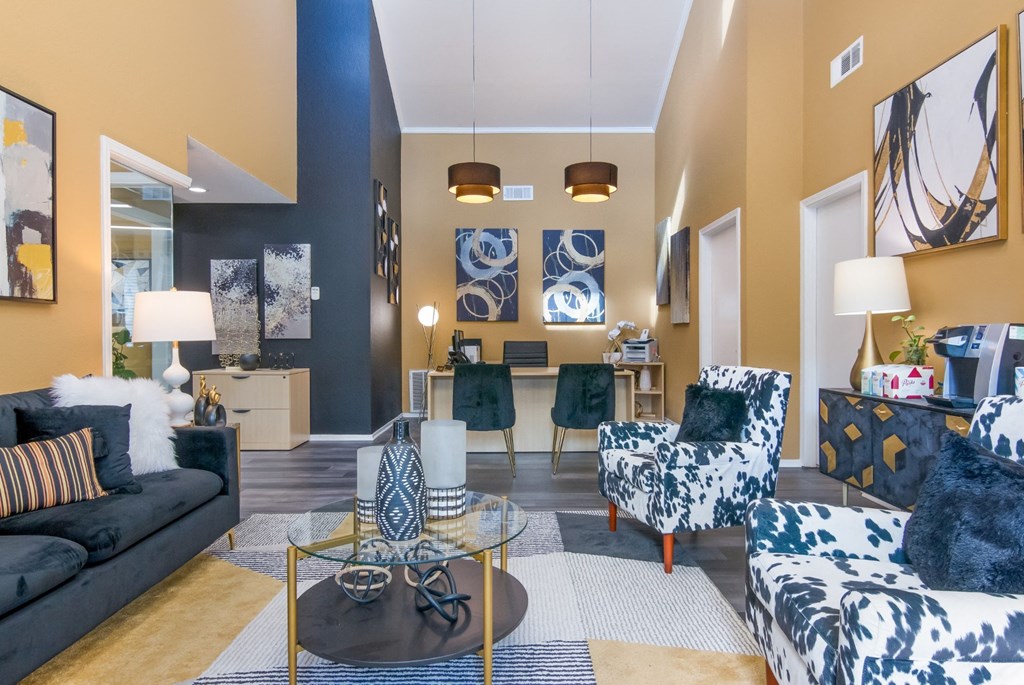 Leasing office interior with a black and white patterned sofa, a black and white patterned chair, and a glass coffee table at Stone Canyon apartments in Shreveport, LA.