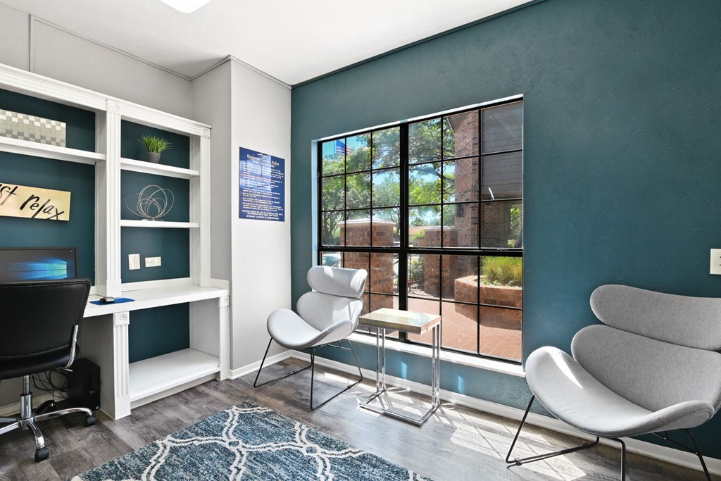 a room with a large window and two chairs