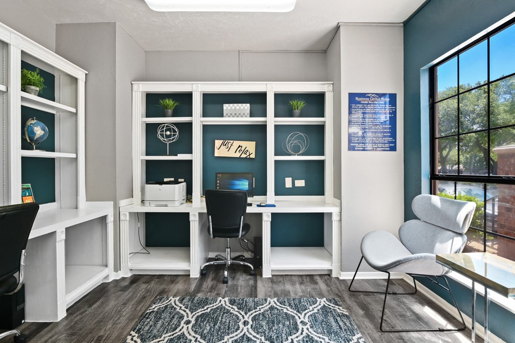 a home office with a large window and a blue accent wall