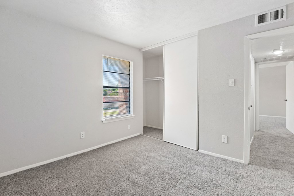 a bedroom with white walls and carpet