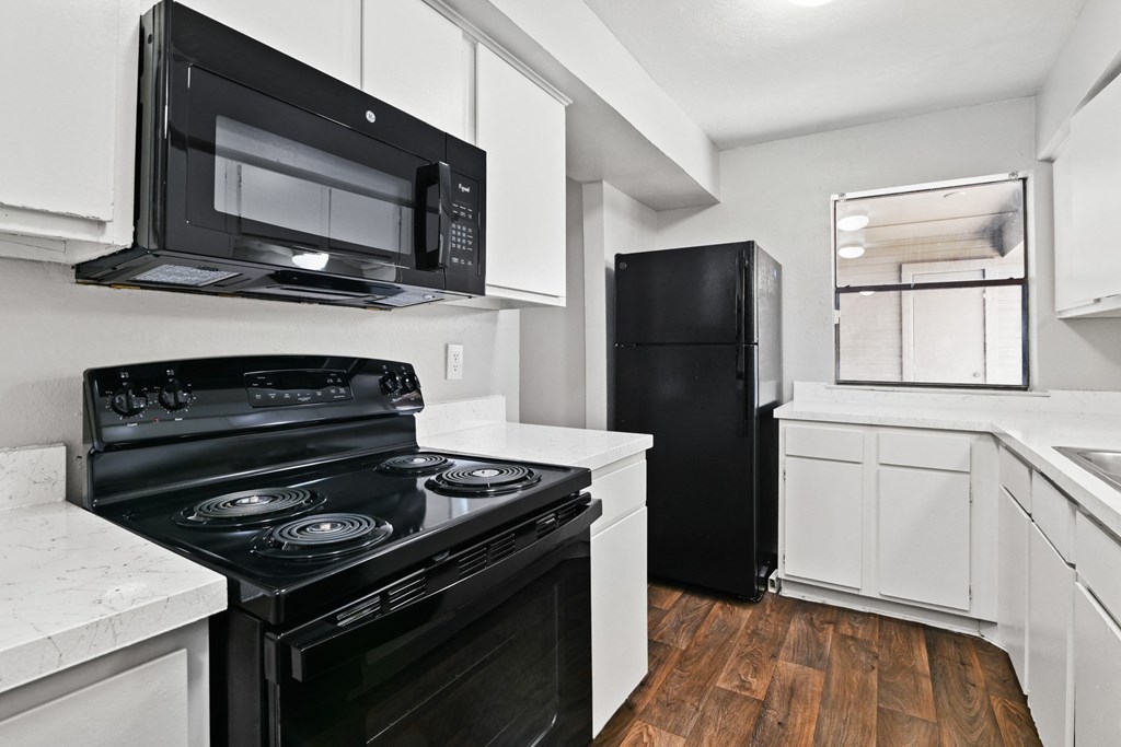 a kitchen with white cabinetry and black appliances