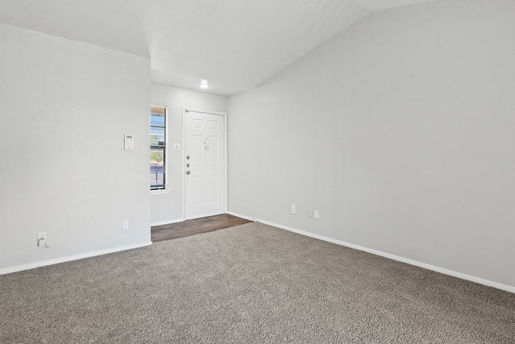 a bedroom with white walls and carpet