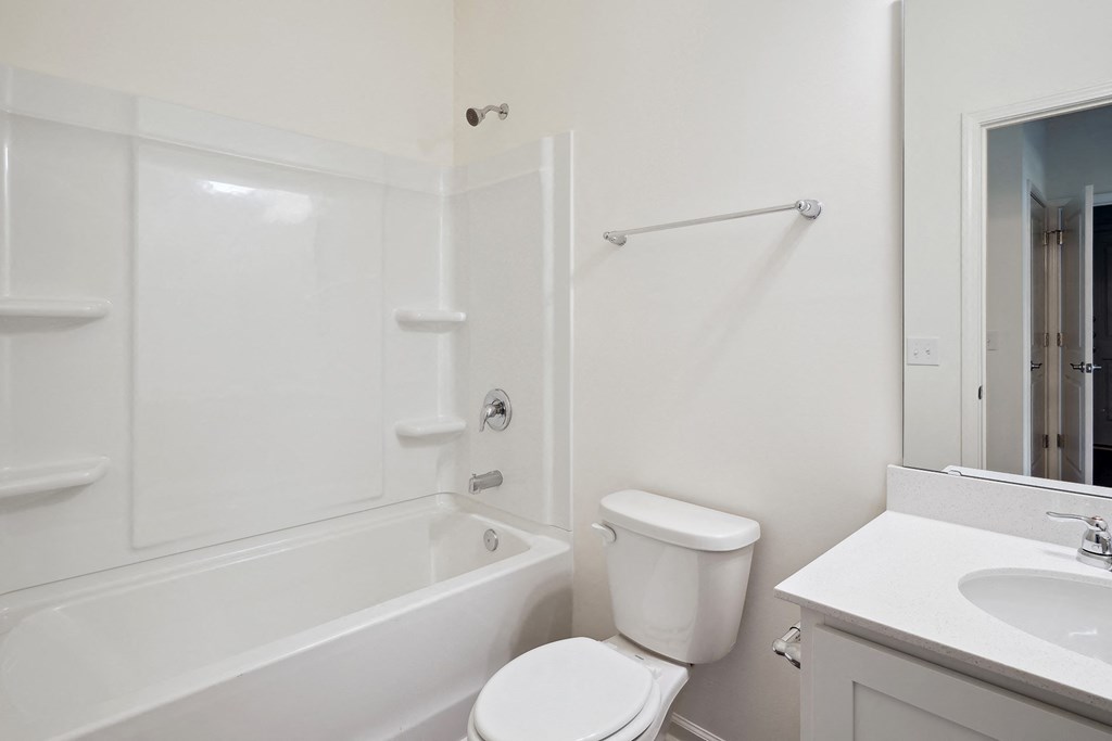 a bathroom with a toilet and a tub and a sink