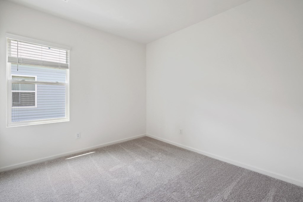 an empty room with white walls and a window