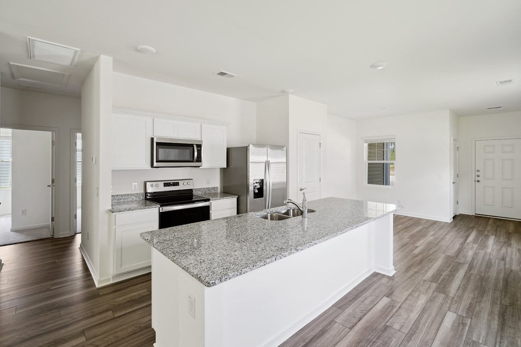 a kitchen with white cabinets and a granite counter top