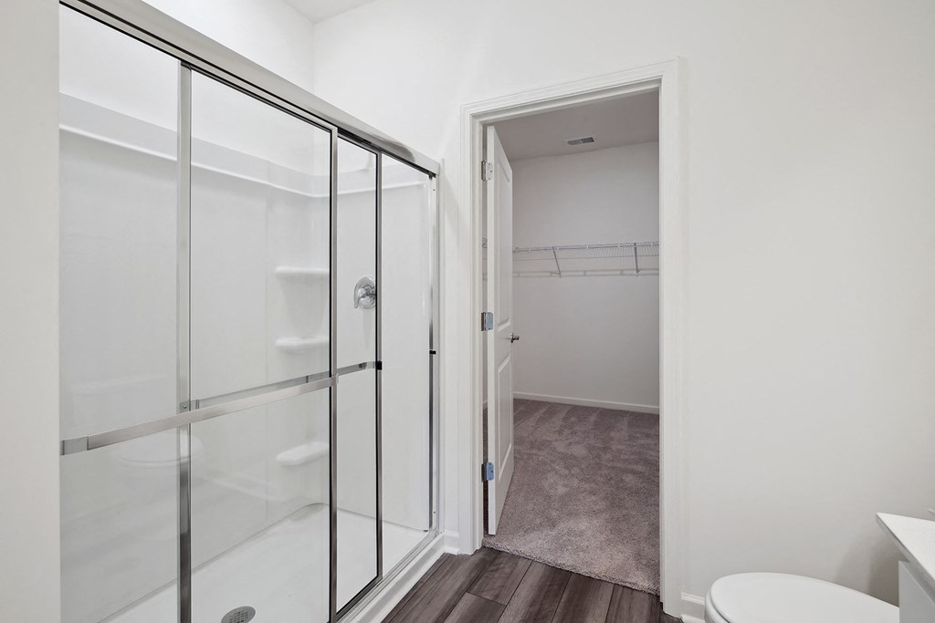 a bathroom with a glass shower and a toilet