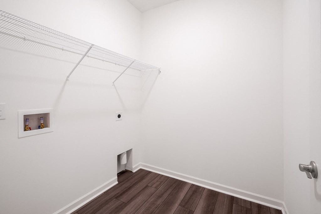 a room with white walls and a wooden floor and a window