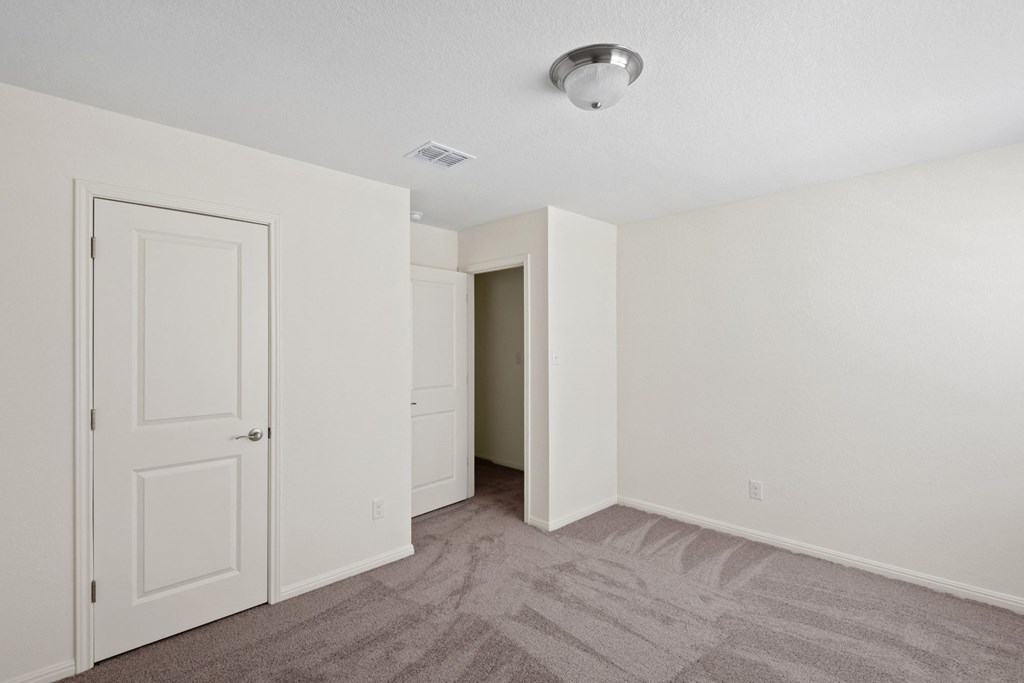 a bedroom with white walls and carpet