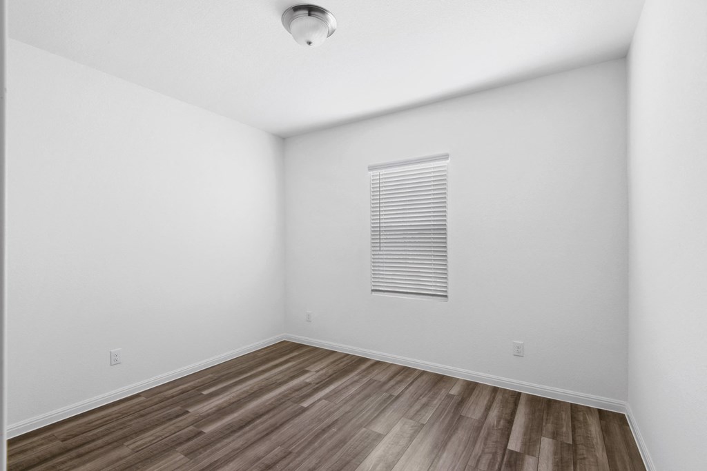 a room with hardwood floors and white walls