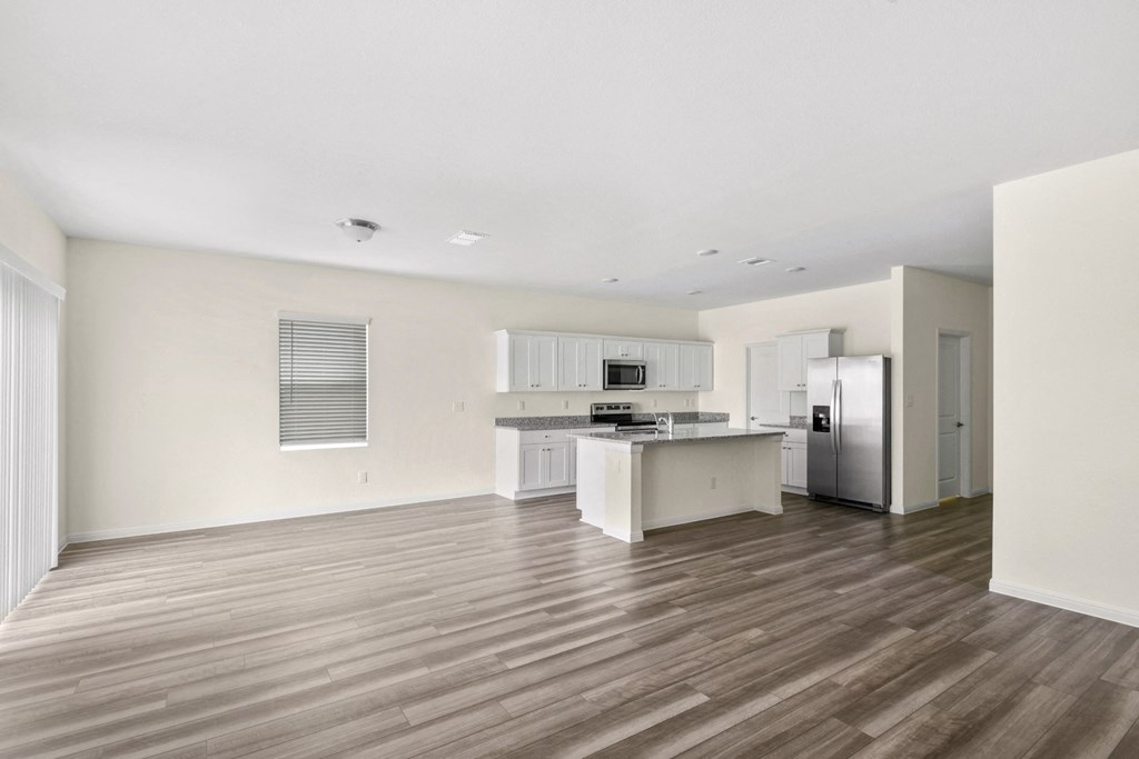 spacious family living room with kitchen and wood floor