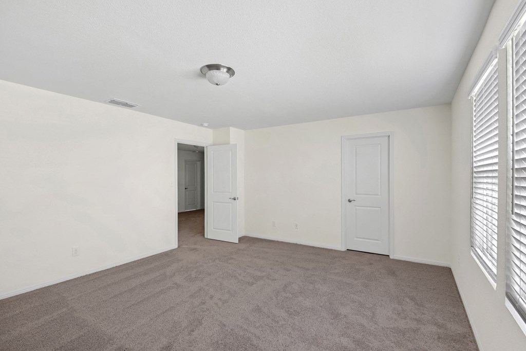 a bedroom with white walls and a carpeted floor