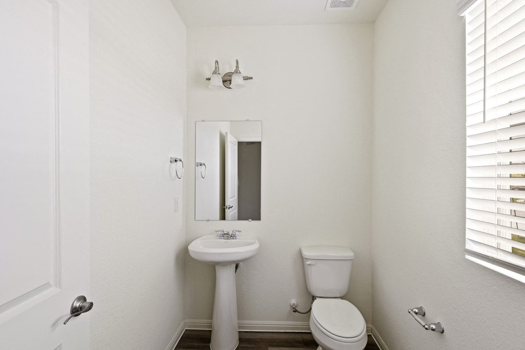a bathroom with a toilet sink and mirror
