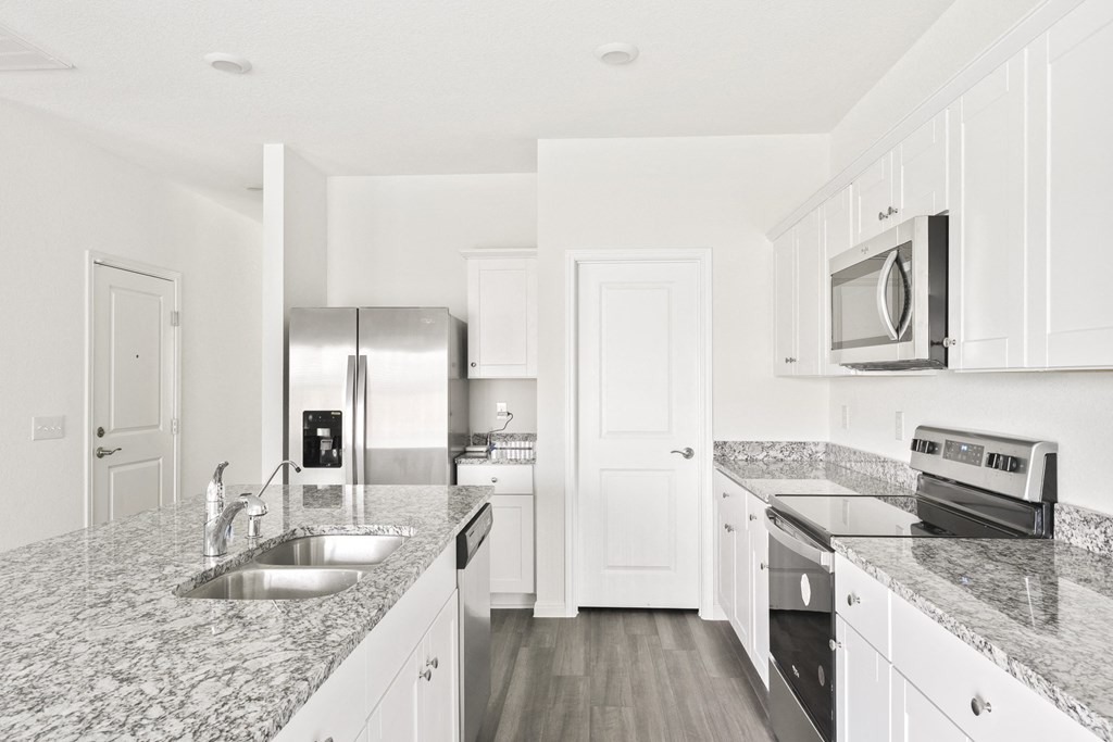 a kitchen with granite countertops and stainless steel appliances