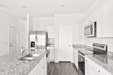 a kitchen with granite countertops and stainless steel appliances at Beacon at Presidential Heights, Texas