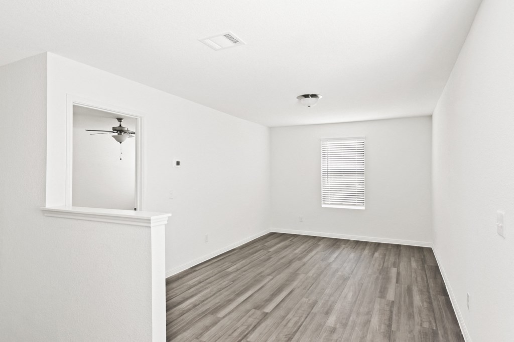 a loft bedroom with hardwood floors and white walls