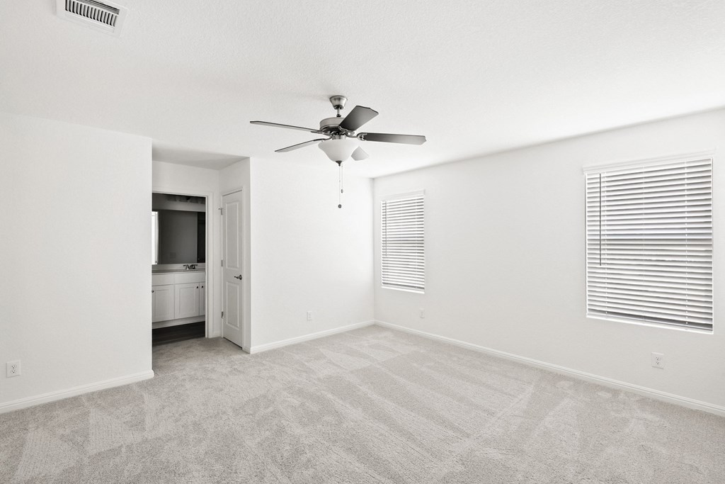 master bedroom with a ceiling fan and white wallls