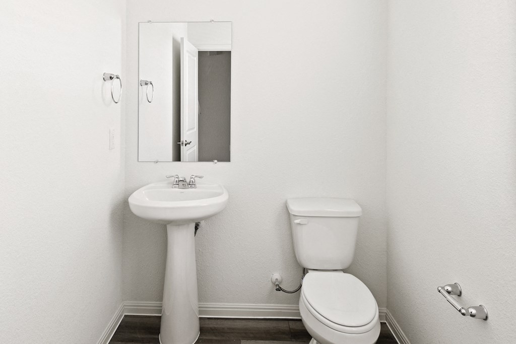 a bathroom with a toilet sink and mirror