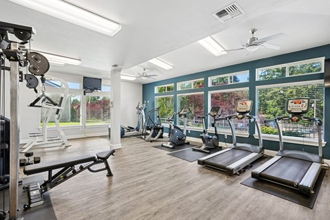 A gym with treadmills, weights, and exercise equipment at The Madison apartments in Olympia, WA
