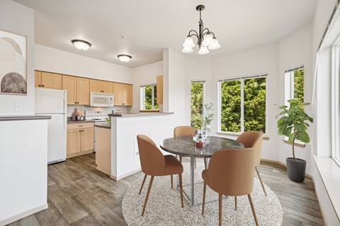 Virtually staged kitchen in the Jackson floor plan with a dining table at The Madison apartments in Olympia, WA