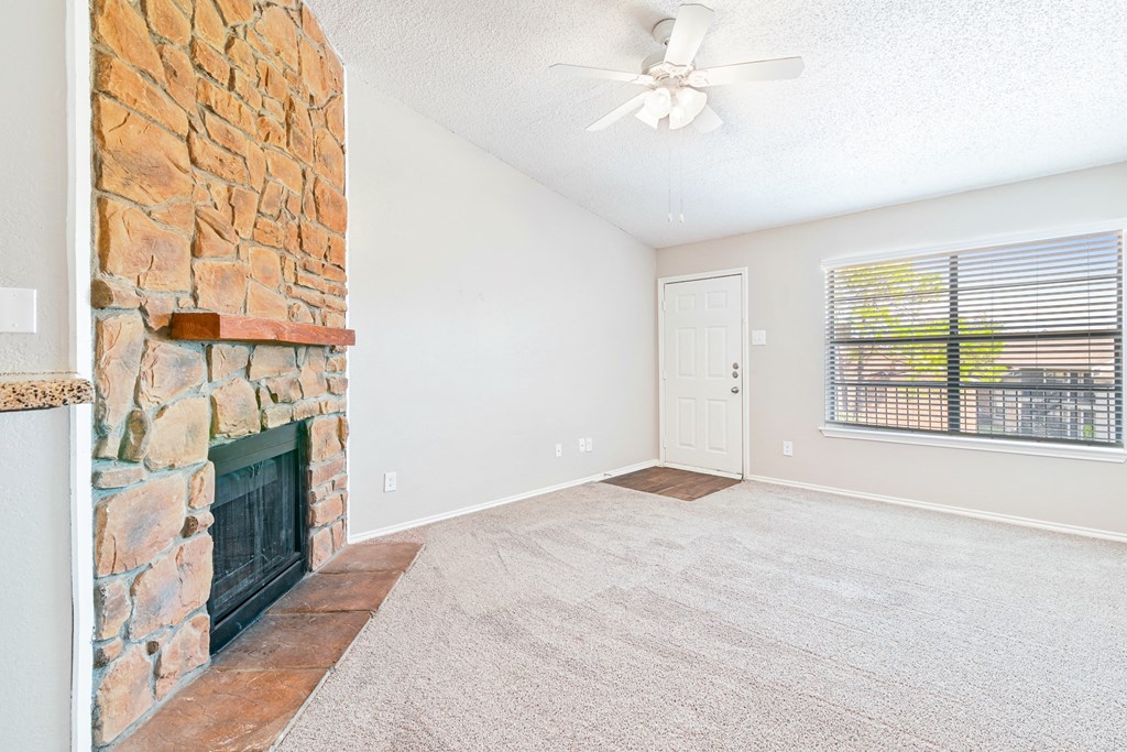 Carpeted Living Room at Terrace at Bookstone and Terrace Apartments in Irving, Texas