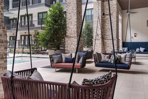 outdoor seating area next to the pool at The Alastair at Aria Village Apartment Homes in Sandy Springs, Georgia, GA