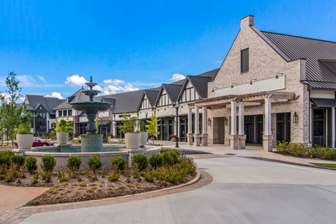 a fountain sits in the center of a roundabout in front of a building