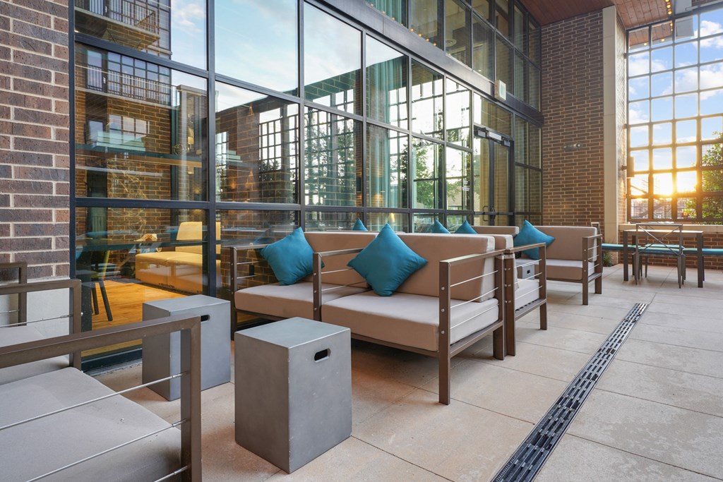 a seating area with couches and tables in front of a large window at The Case Building in Dallas, TX