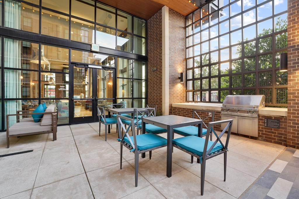a patio with tables and chairs and a grill at The Case Building in Dallas, TX