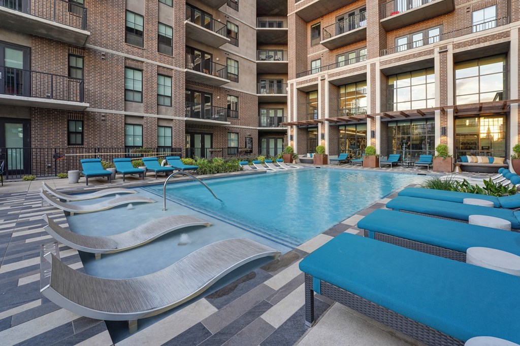 a swimming pool with chaise lounge chairs at The Case Building in Dallas, TX
