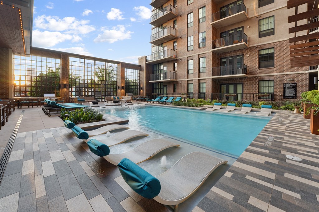 an outdoor pool with lounge chairs at The Case Building in Dallas, TX