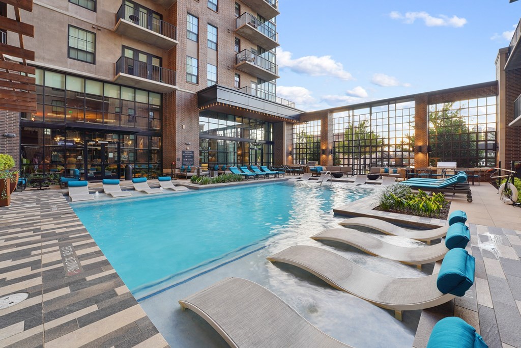 a swimming pool with lounge chairs at The Case Building in Dallas, TX