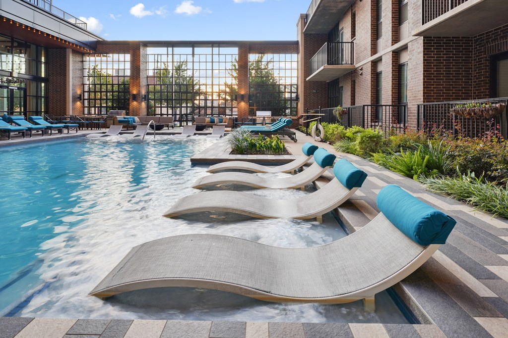 a swimming pool with chaise lounge chairs at The Case Building in Dallas, TX