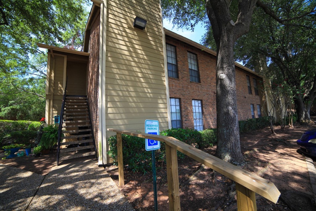 a building with stairs and a blue handicap sign in front of it