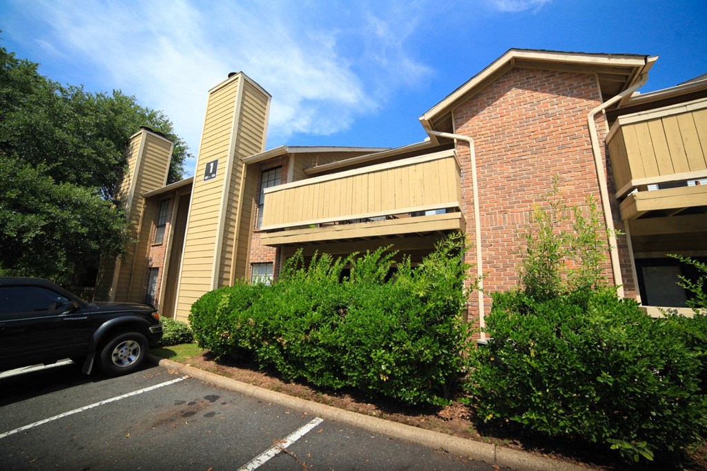 a car parked in a parking lot in front of an apartment building