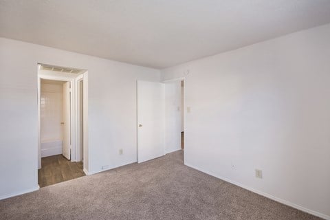 an empty bedroom with white walls and a carpeted floor