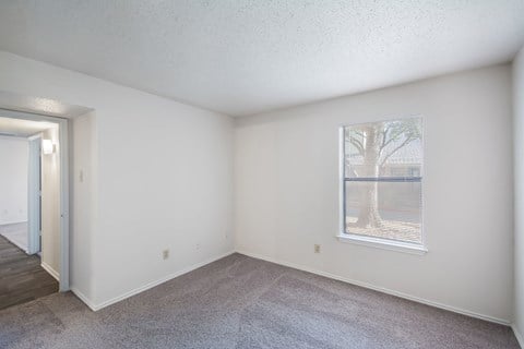 an empty living room with a window and a door