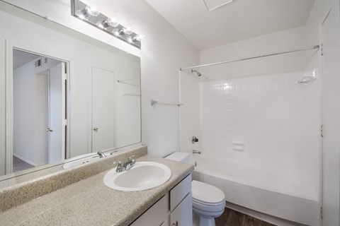 A white bathroom with a sink, toilet, and bathtub.