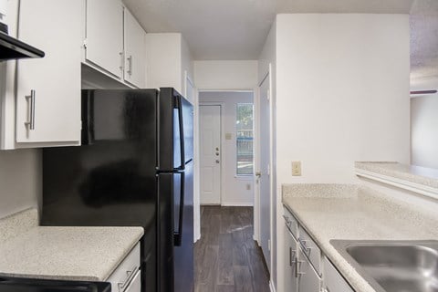 the preserve at ballantyne commons apartment kitchen with black refrigerator and white cabinets