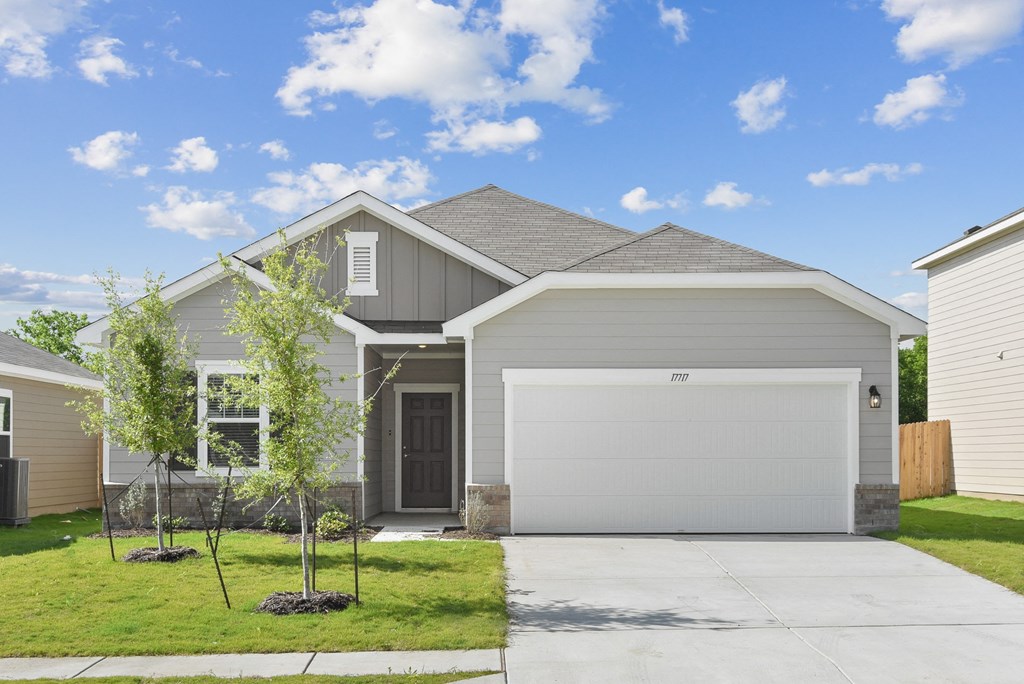 a home with a gray siding and a white garage door at Beacon at Vine Creek, Pflugerville, TX