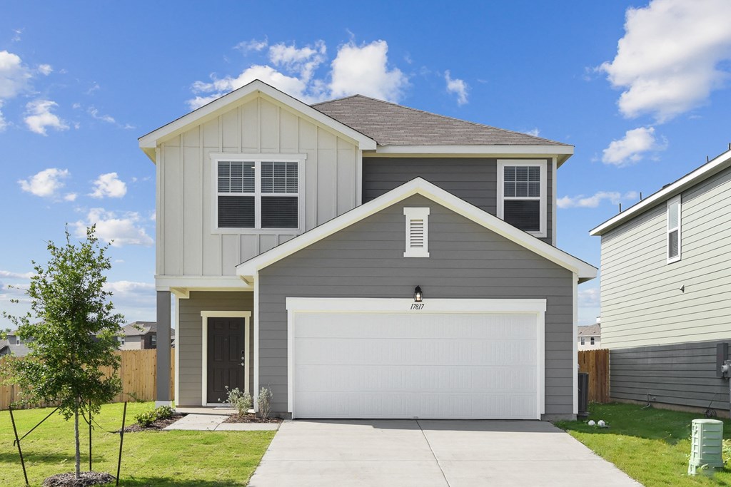 a home with a gray siding and a white garage door at Beacon at Vine Creek, Texas