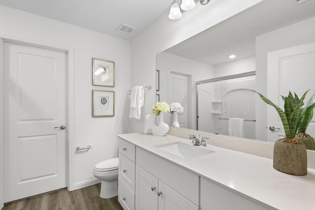 a bathroom with white cabinets and a white toilet  at Beacon at Vine Creek, Pflugerville, TX
