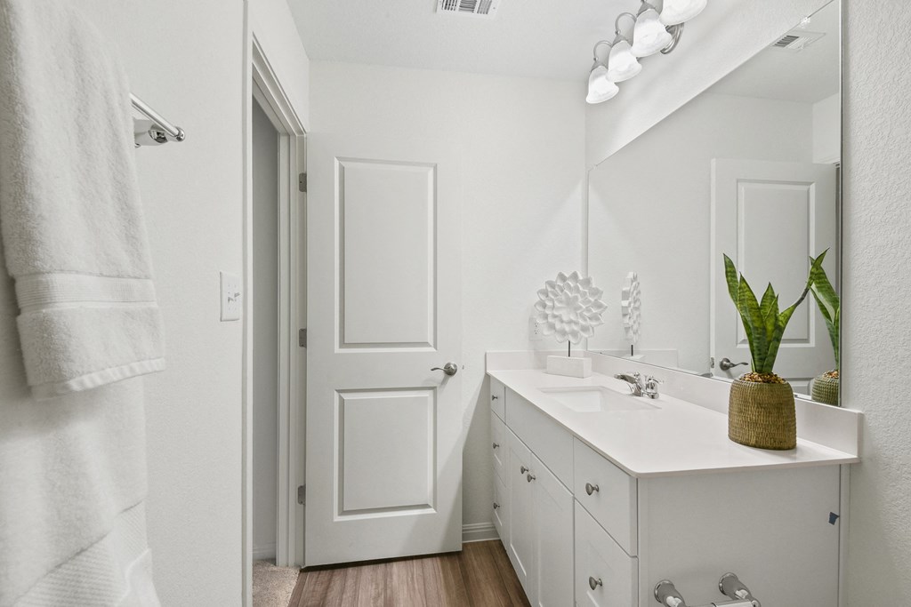 a bathroom with a sink and a mirror  at Beacon at Vine Creek, Pflugerville, Texas