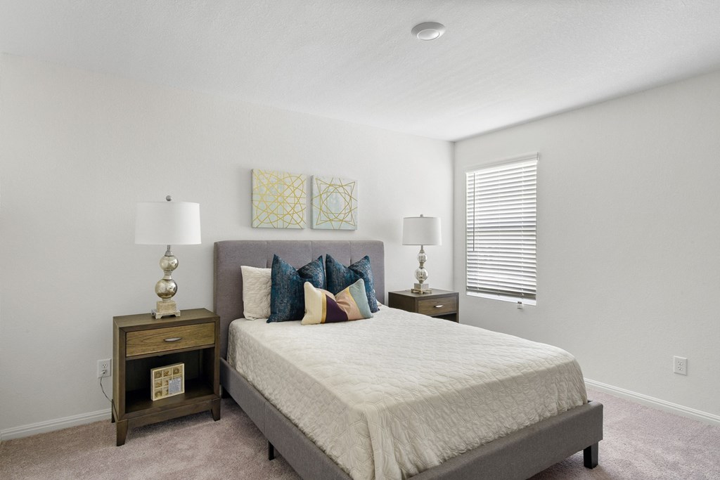 a bedroom with a large bed and two night stands with lamps at Beacon at Vine Creek, Pflugerville, TX, 78660