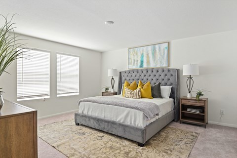 a bedroom with a bed and two windows  at Beacon at Vine Creek, Pflugerville, TX