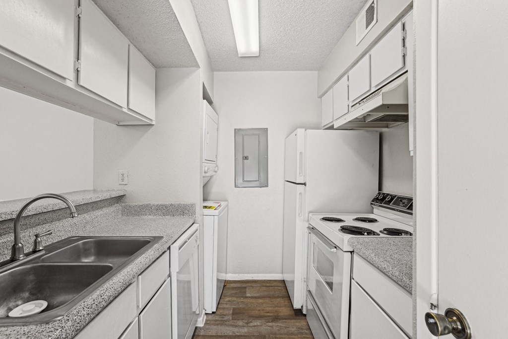 A1 kitchen with white cabinets and a stove top oven at Vine Apartments in Arlington, TX