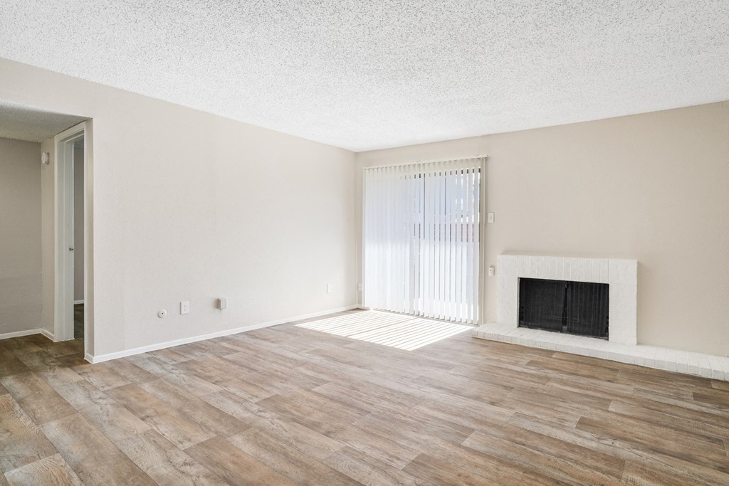 A1 living room with a fireplace and wood flooring at Vine Apartments in Arlington, TX