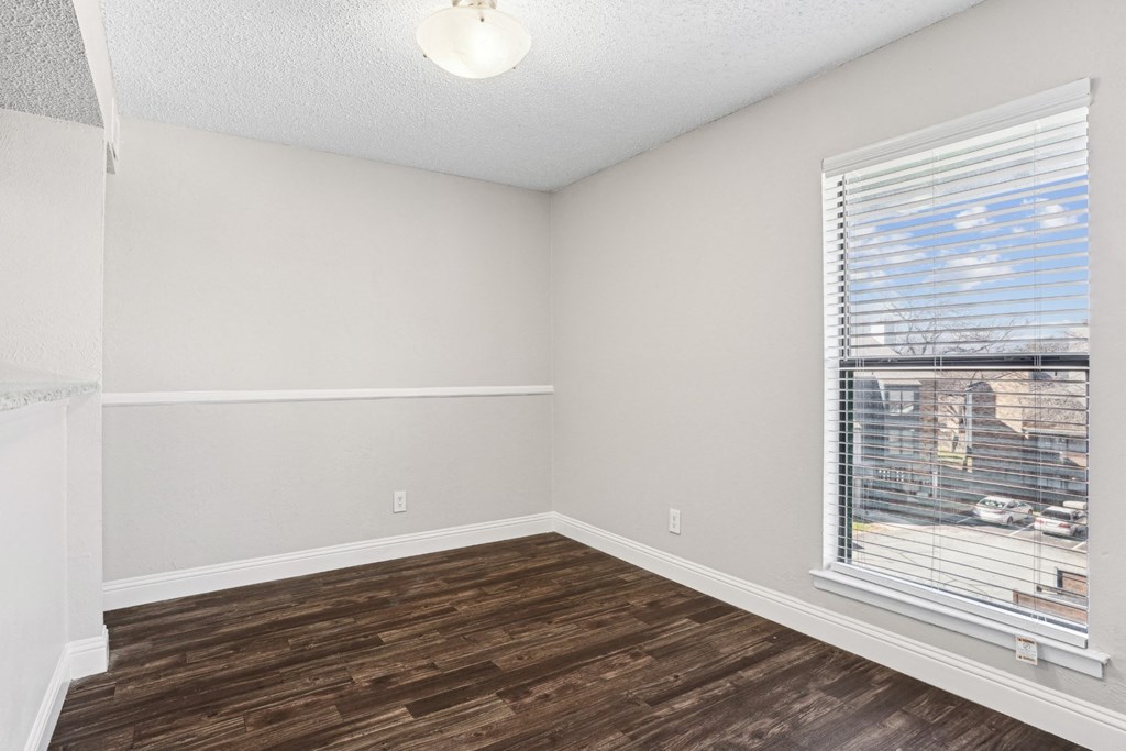 B1 bedroom with a window and wooden flooring at Vine Apartments in Arlington, TX