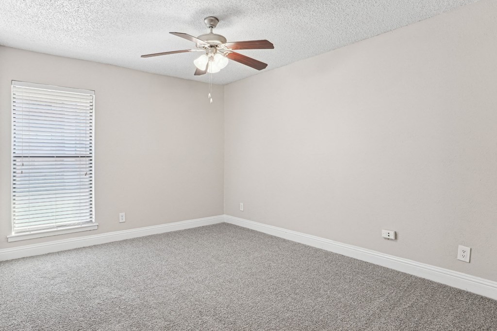 B1 bedroom with a ceiling fan and carpeted floor at Vine Apartments in Arlington, TX